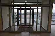 Automatyczne drzwi przesuwne z aluminium stanowiące główne wejście do budynku biurowego. Wyposażone w czujniki ruchu kontrolujące napęd