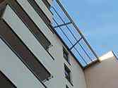 Zadaszenie balkonów z gładkich, przeźroczystych płyt z poliwęglanu montowanych na konstrukcji wsporczej z profili ze stali ocynkowanej malowanej proszkowo