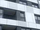 Panele elewacyjne z alucobondu, z tyłu balustrada balkonowa z profili stalowych