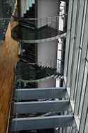 Balustrada całoszklana z poręczą ze stali nierdzewnej zamontowana na schodach klatki schodowej