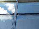 Panele ze szkła mocowane do konstrukcji wsporczej za pomoca listwy aluminiowej. Widoczne taśmy izolacyjne z gumy