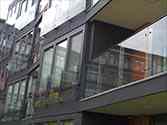 Balkony francuskie (portfenetr) z paneli szklanych zamocowanch do ramy nośnej ze stali za pomocą uchwytów punktowych